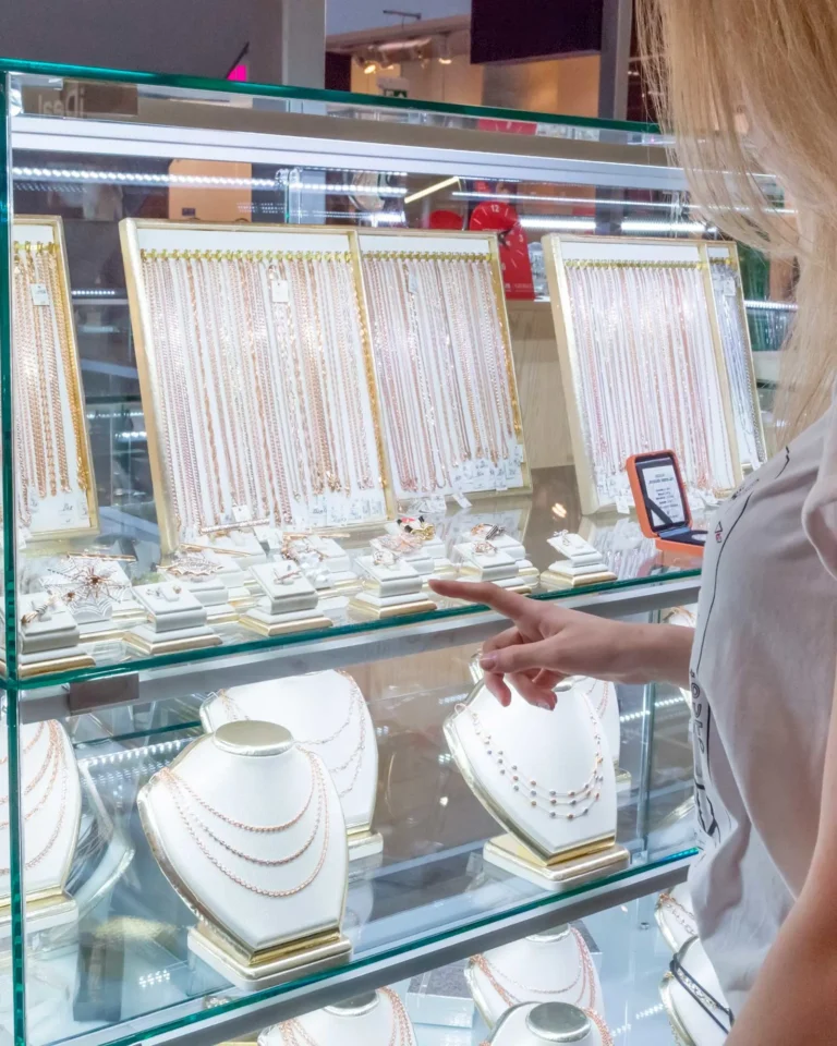 Woman browsing necklaces in a jewelry store display case in Orlando