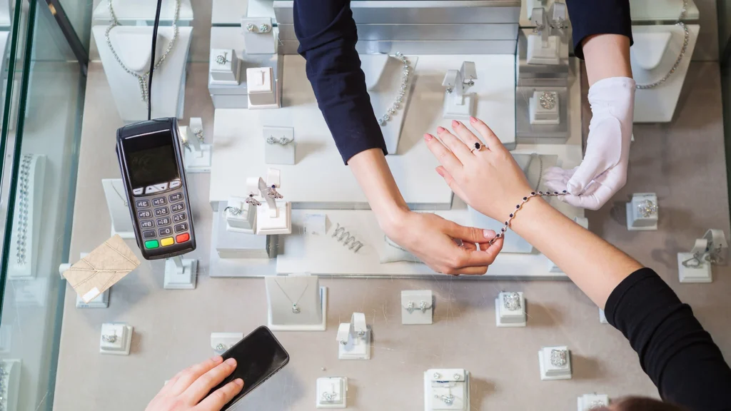 Customer trying on a bracelet with sales assistance at an Orlando jewelry store