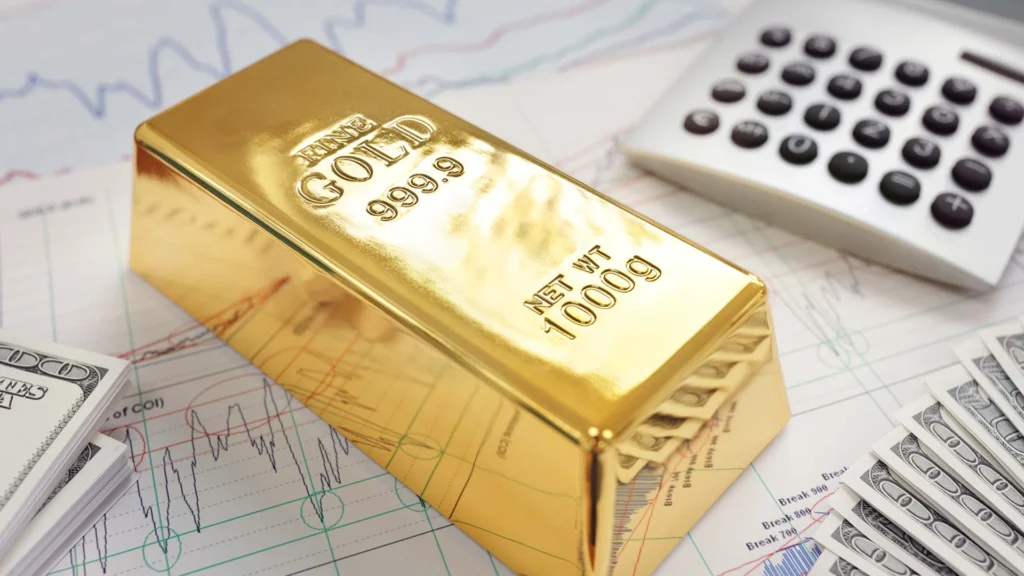 fine gold bar resting on financial charts, with dollar bills and a calculator nearby, symbolizing investment and growth